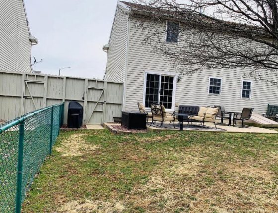 backyard lawn and green fence of new home for sale