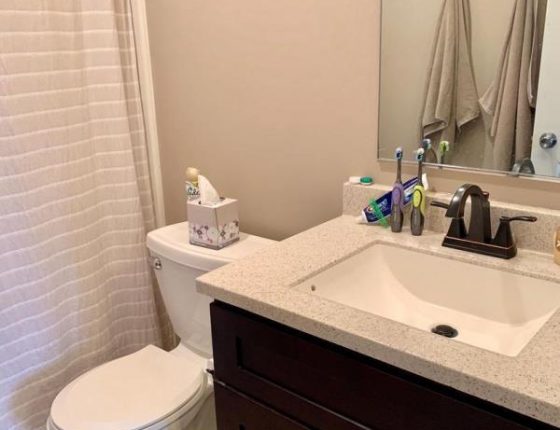 modern bathroom sink and toilet sitting new to shower in new home for sale