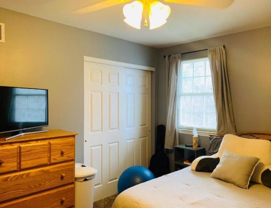 white double closet doors next to dresser with television set on top