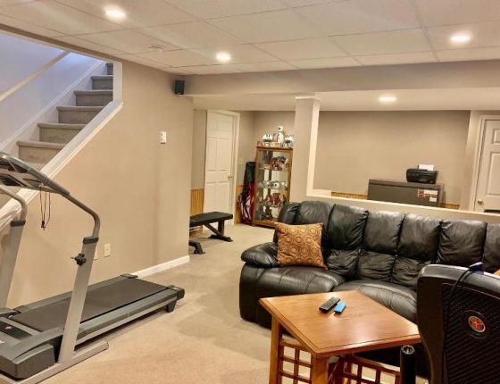 leather couch and treadmill in basement of new home for sale