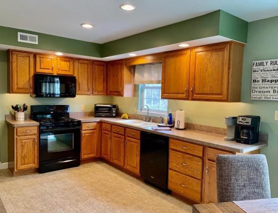 brown kitchen cabinets and black kitchen appliances in new home for sale