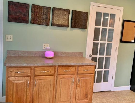 kitchen cabinets sitting beneath wall decorations and beside white door