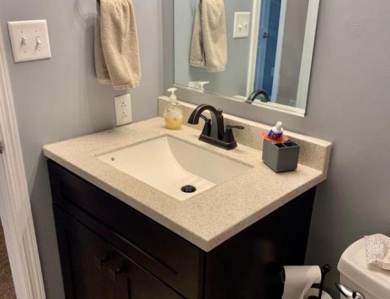 modern sink in corner of bathroom with soap and toothpaste holder sitting on top