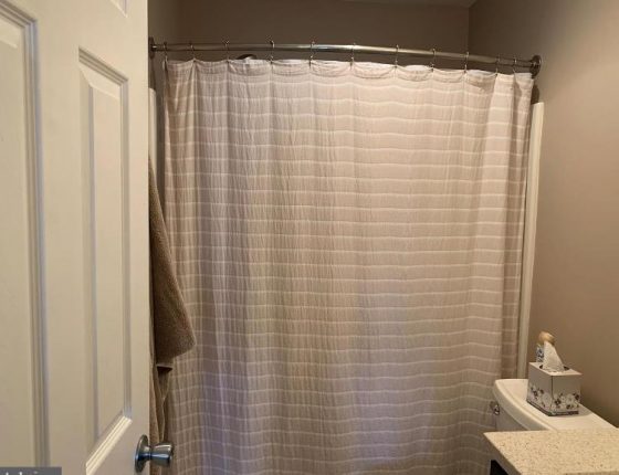 white door and pink shower curtain in new home for sale