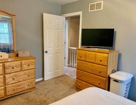 upstairs bedroom furniture and white open door leading to hallway