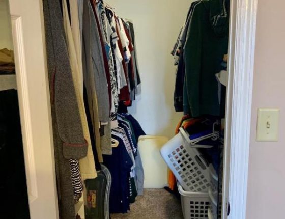 large walk in closest filled with clothes and hampers in new home for sale