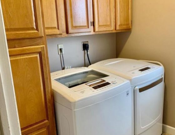 washer and dryer sitting beneath cabinetry in wilson school district home for sale