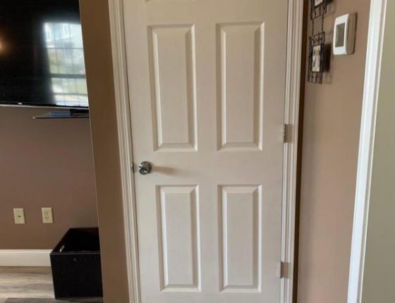 white door sitting next to television set hung on wall